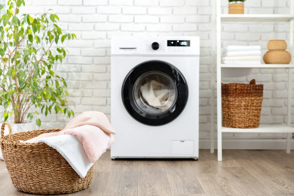 Modern white washing machine close up photo in laundry room