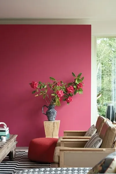 pink flowers in a grey base on top of wood with a pink background
