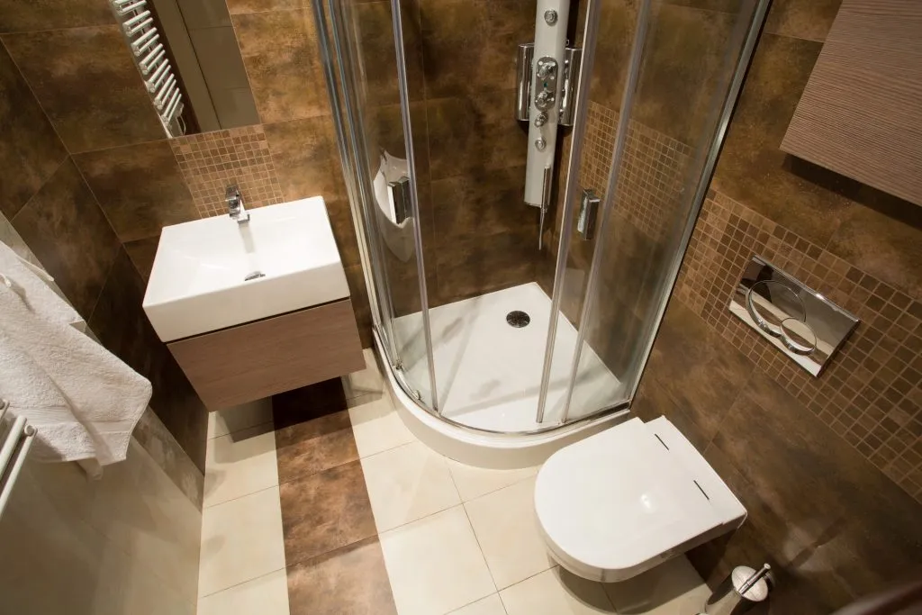 View from the top of small bathroom with brown tiles
