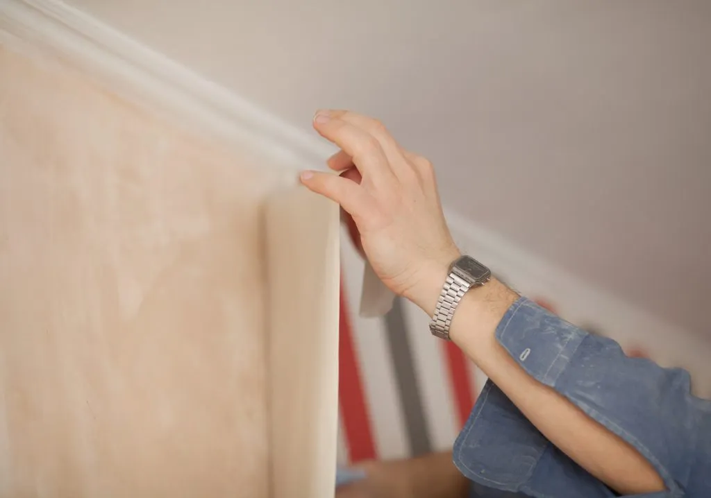 Glueing wallpapers at home. Handyman putting up wallpaper on the wall